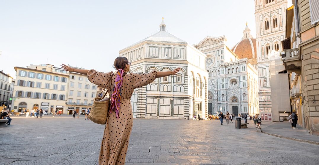 Woman enjoys view on an Italian plaza wondering about the best way to learn Italian