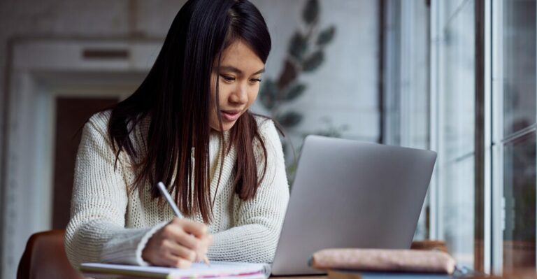 Ragazza asiatica, seduta la suo pc, imparando l'alfabeto italiano con le classi di Lingoda