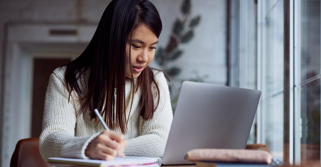 Ragazza asiatica, seduta la suo pc, imparando l'alfabeto italiano con le classi di Lingoda