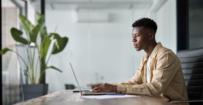 jeune homme assis à son bureau apprenant les articles définis et indéfinis en français