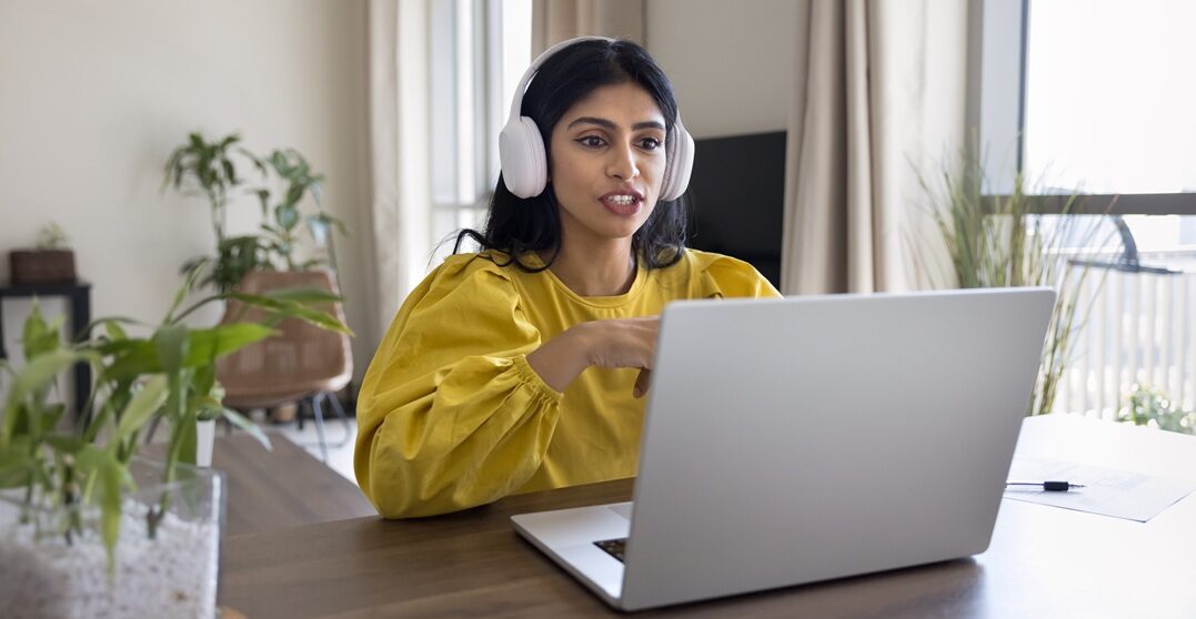 Young Indian woman at hedr desk rehearsing some long German words with Lingoda