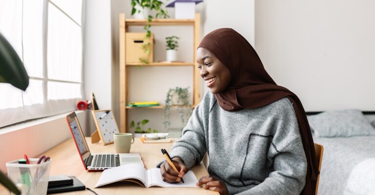 Young woman at her desk studying German modal particles with Lingoda