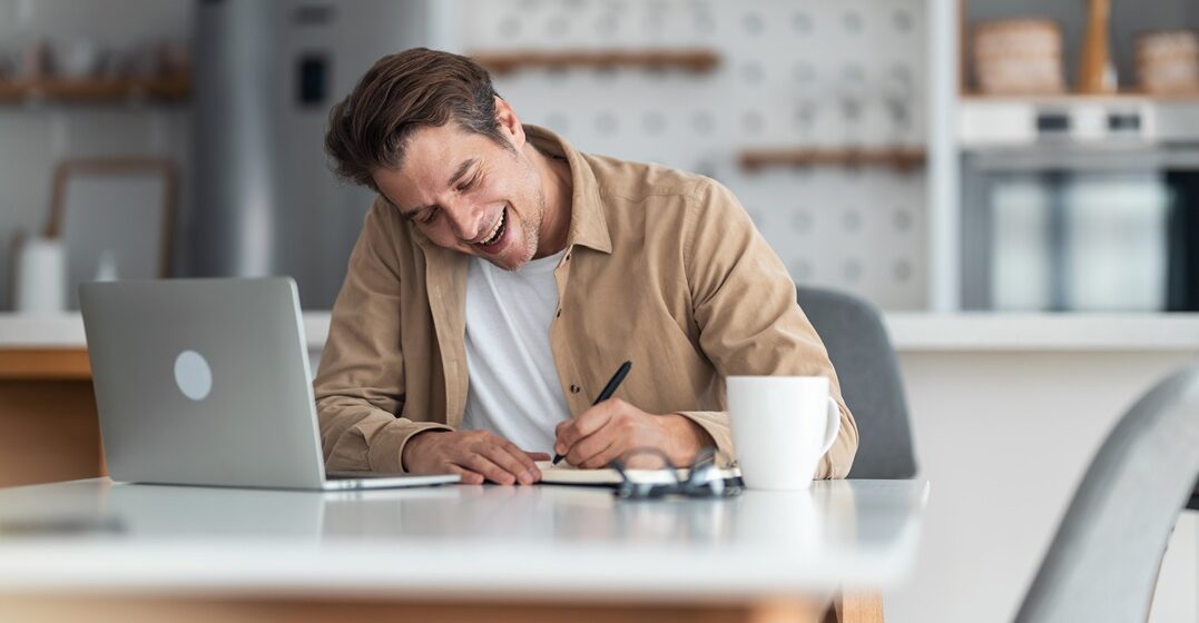young man at his desk, writing down notes on the german past participle