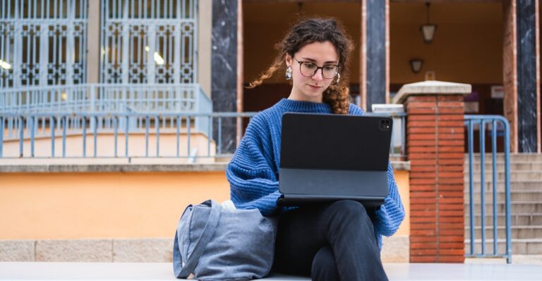 Junge Studentin am Laptop lernt den Plural auf Deutsch