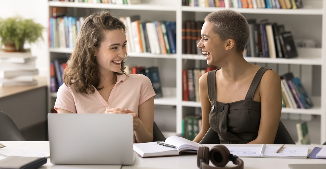 Zwei junge Frauen üben zusammen das Verb werden