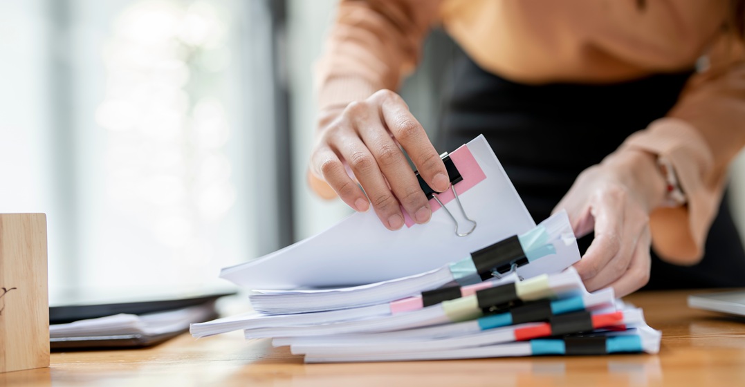 Woman sorting paperwork as part of German bureaucracy