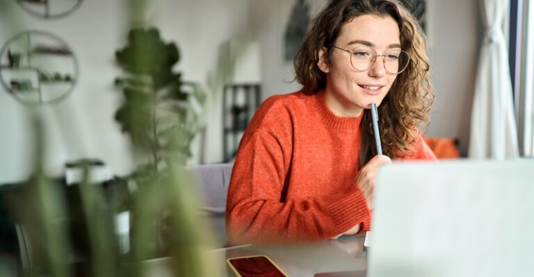 Young woman learning the past tense of to be online at her laptop