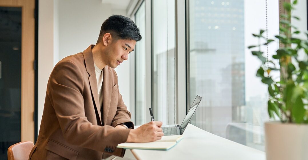 young asian man studying at a bar next to a huge window two way prepositions in german