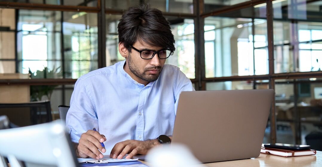 Indian young man learning on his laptop the werden conjugation in German