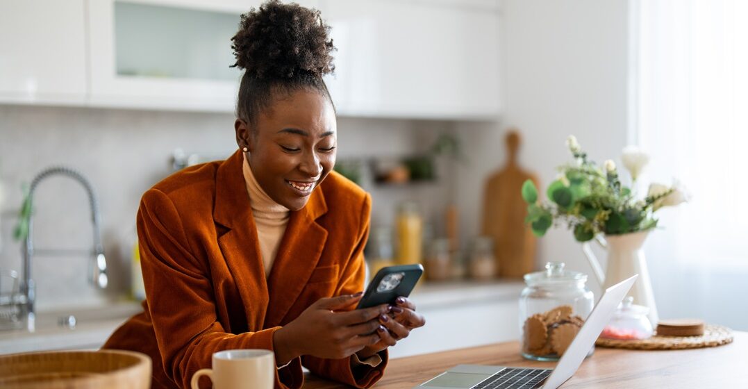 Young African American woman in her kitchen in Germany freelancing.