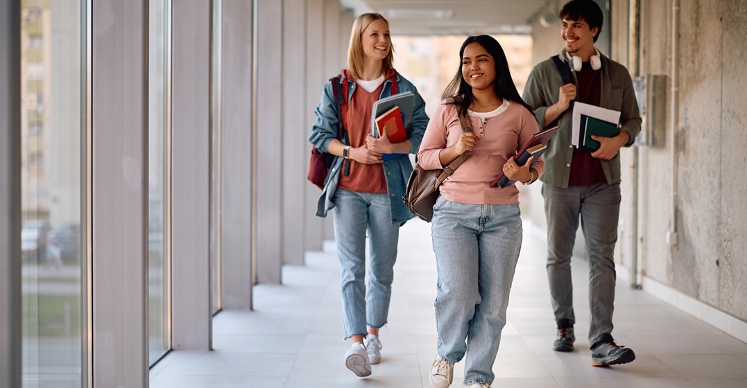 Three happy students are walking to an integration course in Germany