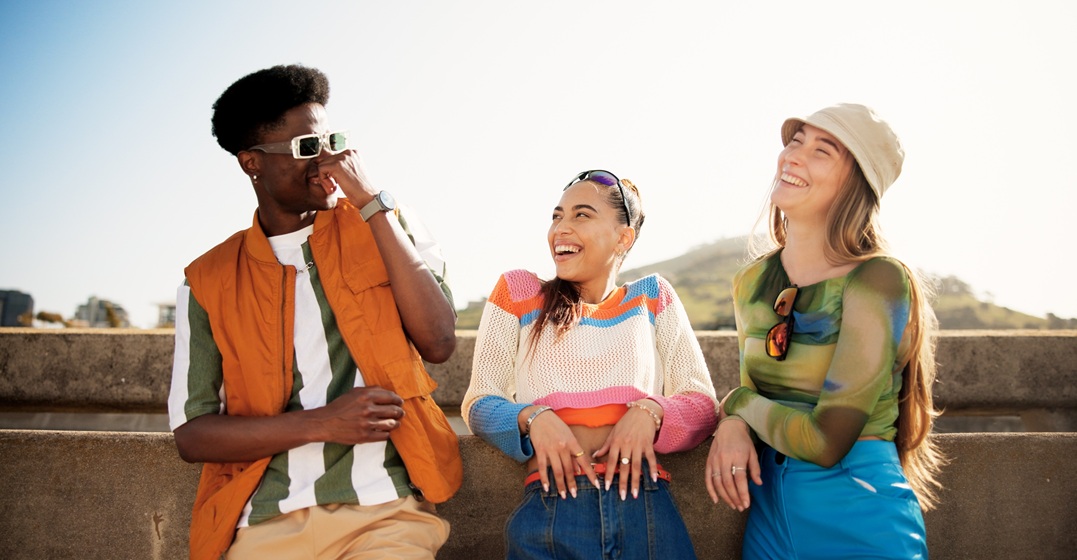Three friends laughing and practicing how to say