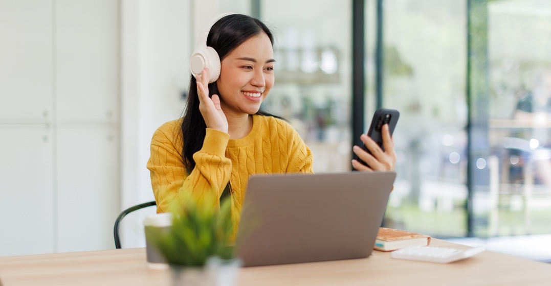 Eine Studentin sitzt an ihrem Laptop und lernt die indirekten Fragen auf Deutsch